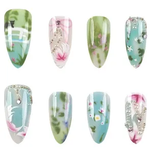 Mintgroene kunstnagels met elegante tuinbloemkunst, parels en schattige kattenmotieven.