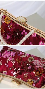 Detailed view of burgundy sequin floral evening clutch with gold frame and pearl handle.