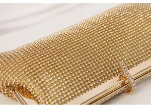 Nahaufnahme einer luxuriösen goldenen Strass-Abendtasche mit glänzenden Kristallsteinen.