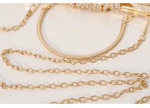 Golden evening bag detail shot featuring metallic chain straps and rhinestone clasp hardware.