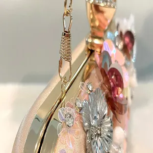 Handmade floral evening clutch bag featuring delicate metallic flowers and sparkling rhinestones.