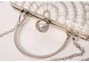 Dettaglio ravvicinato di elegante borsa da sera con perle raffinate e strass luminosi.