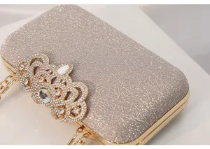 Bolso de noche brillante con cierre de corona de pedrería y elegante cadena dorada fina.