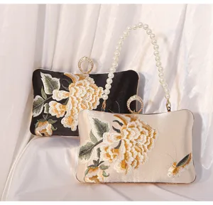 Detail view of vintage silk embroidered evening clutch bag with exquisite floral details.