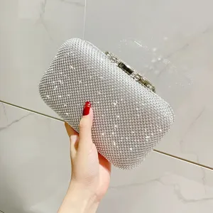 Silver rhinestone evening clutch bag detail showing sparkling crystal diamonds and metal clasp lock.