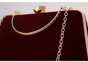 Elegant velvet evening clutch bag detail, gold metal frame, chain strap, party dress purse.