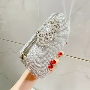 Silver rhinestone evening clutch bag with sparkling crystals and elegant floral clasp design.