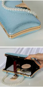 Elegant blue glitter evening clutch bag with pearl handle and gold leaf clasp detail.