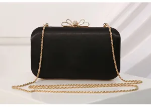Black satin evening clutch bag with gold bow clasp and chain strap detail for women dress events.