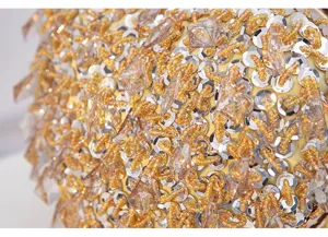 Close-up detail view of luxury beaded sequin evening bag craft and sparkling crystal pendants.