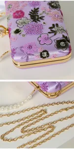 Detailansicht einer lila Pailletten Blumen bestickten Abendtasche mit Goldrahmen und Kette.