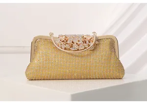 Gold rhinestone evening clutch bag with metallic frame and floral clasp for formal party.