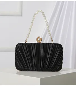 Elegant black pleated evening clutch bag with pearl handle and clasp detail for dress.