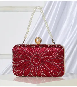 Red rhinestone evening clutch bag with pearl handle and floral crystal design for women.