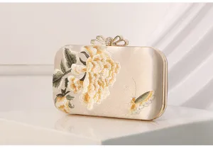 Elegant satin evening clutch bag with exquisite floral embroidery and metallic bow lock design.