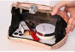Pink evening clutch bag interior display showing capacity with mobile phone and cosmetics.