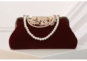 Vintage burgundy velvet evening clutch bag with pearl handle and rhinestone metal clasp.