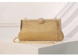Gold rhinestone evening clutch bag detail, sparkling crystal flower clasp with metal chain.