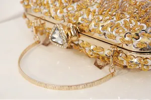 Detailopname van gouden kraaltjes avondtas clutch met sprankelende kristallen en metalen handvat.