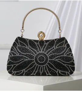 Primer plano del bolso de noche negro con brillantes pedrería y un elegante cierre de perlas.