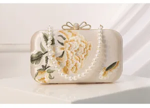 Exquisite embroidered evening clutch bag with pearl handle, elegant Chinese style flower detail.