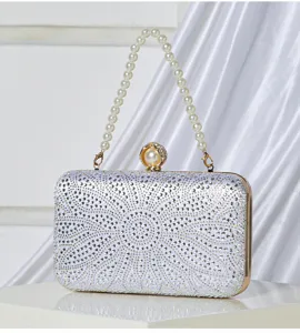 Closeup detail view of silver rhinestone evening clutch bag featuring elegant pearl handle and clasp.