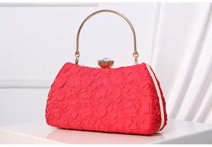 Detailed view of elegant red evening clutch with gold metal ring handle and crystal clasp.