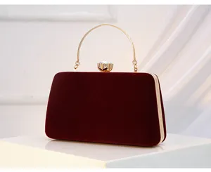 Elegant burgundy velvet evening clutch bag with gold handle and crystal clasp for parties.