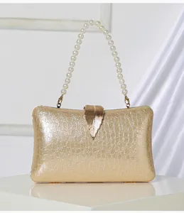 Gold shimmering evening clutch bag with elegant pearl handle and leaf clasp detail.