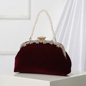 Elegant vintage velvet evening clutch bag with pearl handle and rhinestone metal frame.