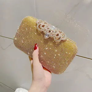 Detailed close-up of sparkling gold rhinestone evening clutch bag with elegant crystal clasp.