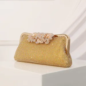 Gold rhinestone evening clutch bag with metal frame and sparkling crystal leaf clasp for women.
