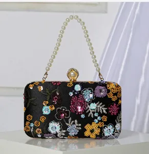 Detailansicht der schwarzen Pailletten bestickten Abendtasche mit Perlenhenkel und Verschluss.