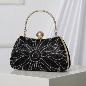 Elegante bolso de noche negro con pedrería, asa dorada y diseño floral de cristales.