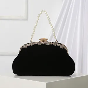Black velvet evening bag with pearl handle and rhinestone clasp, elegant vintage purse for party.