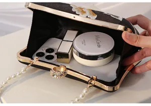 Close-up of black embroidered evening clutch showing spacious interior capacity for daily essentials.