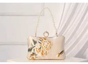Elegant silk evening clutch with pearl handle and traditional floral embroidery for women.
