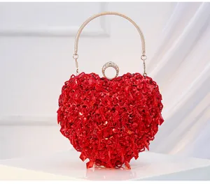 Red heart-shaped sequin clutch bag with metallic handle, perfect for evening parties.