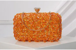 Close-up detail van een oranje avondtas met pailletten en kralen voor een sprankelende look.