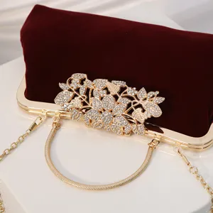 Elegant wine red velvet evening clutch bag with sparkling rhinestone flower clasp and chain.