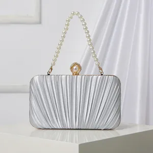 Elegant silver pleated evening clutch bag with pearl handle and stylish clasp for women.