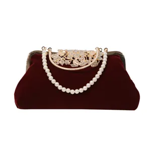 Elegant wine red velvet evening clutch bag with pearl handle and rhinestone metal clasp.