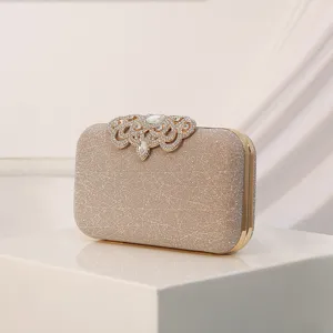 Elegante bolso de mano de noche con purpurina champán, cierre de diamantes y marco.