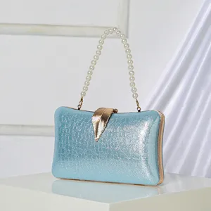 Elegant light blue evening clutch bag featuring pearl handle and gold leaf clasp design.