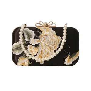 Elegant embroidered evening clutch bag with pearl chain strap and chic floral design for women.
