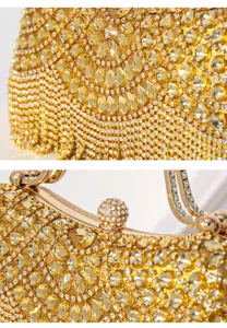 Gold rhinestone evening clutch bag sparkling crystal detail with elegant metallic clasp and tassels.