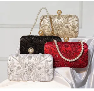 Elegant bead-embroidered evening clutch with pearl handle for weddings and banquets.