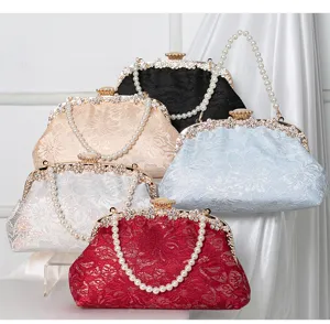 Detailed view of elegant lace evening clutch bags with pearl chains and rhinestone clasps.