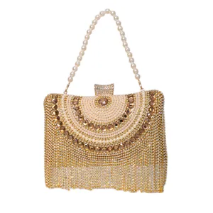 Elegant gold rhinestone evening clutch bag with pearl handle and sparkly fringe details.