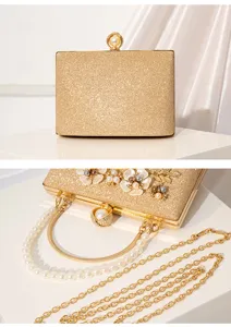 Elegant gold glitter evening clutch with pearl flower decor and detachable chain strap.